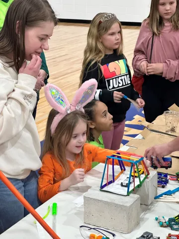 Children work on a bridge building experiment.