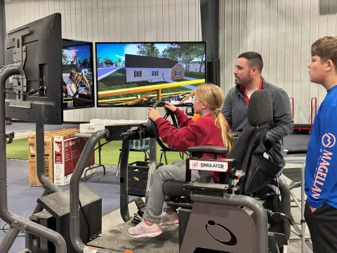 A child tries a virtual reality driving simulator.